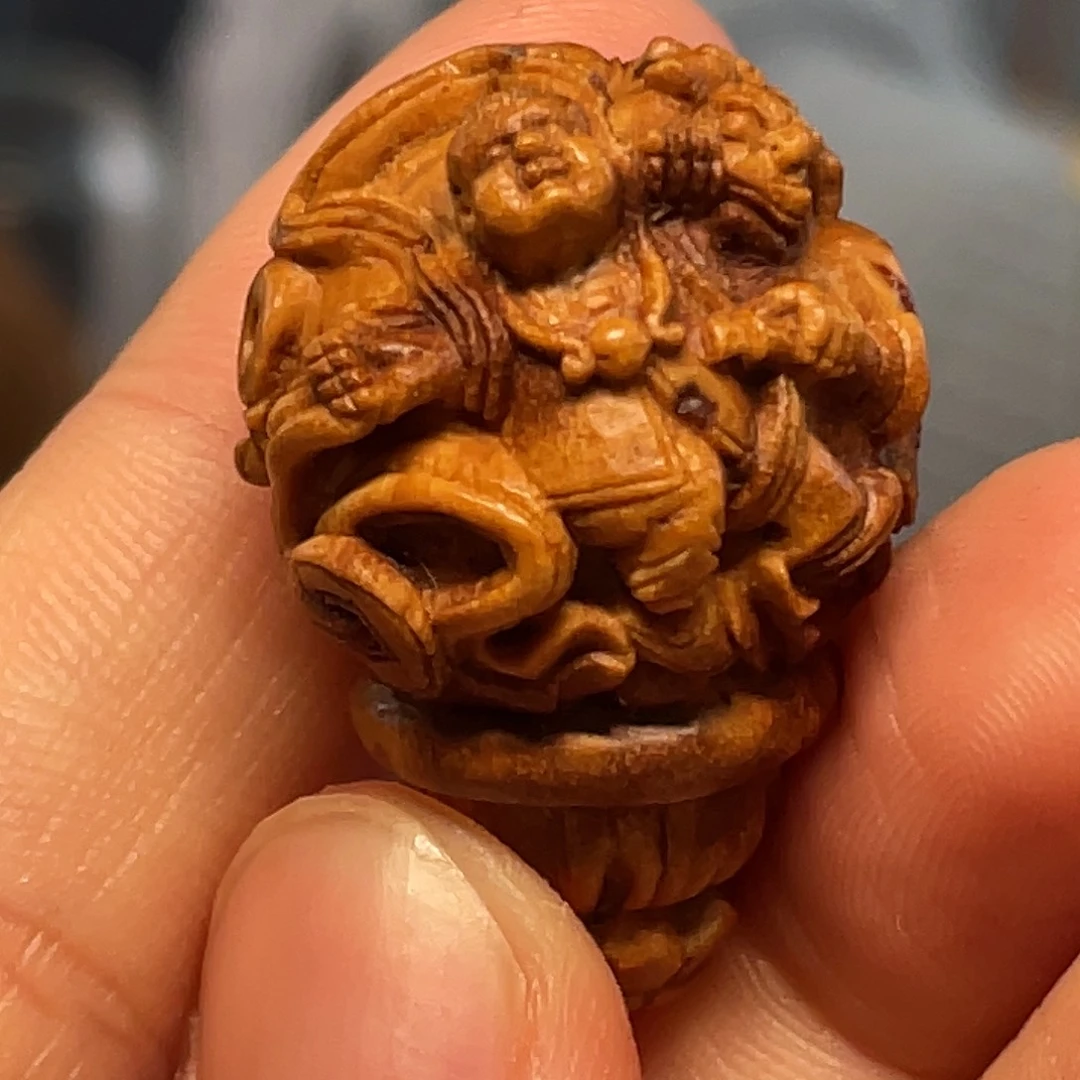 桃核童子戏狮核雕作品