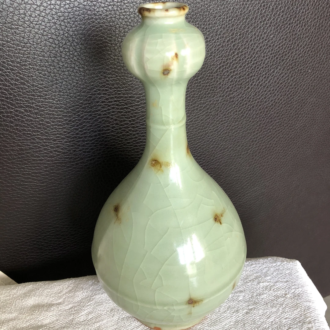 龙泉窑点彩蒜头瓶,高约20厘米,瓶身青白釉色温润,釉面开片自然。