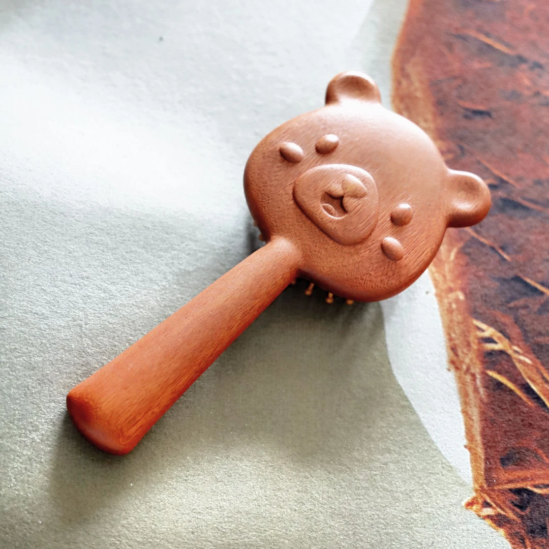 手拿可爱熊通用按摩棒家用按摩气垫梳