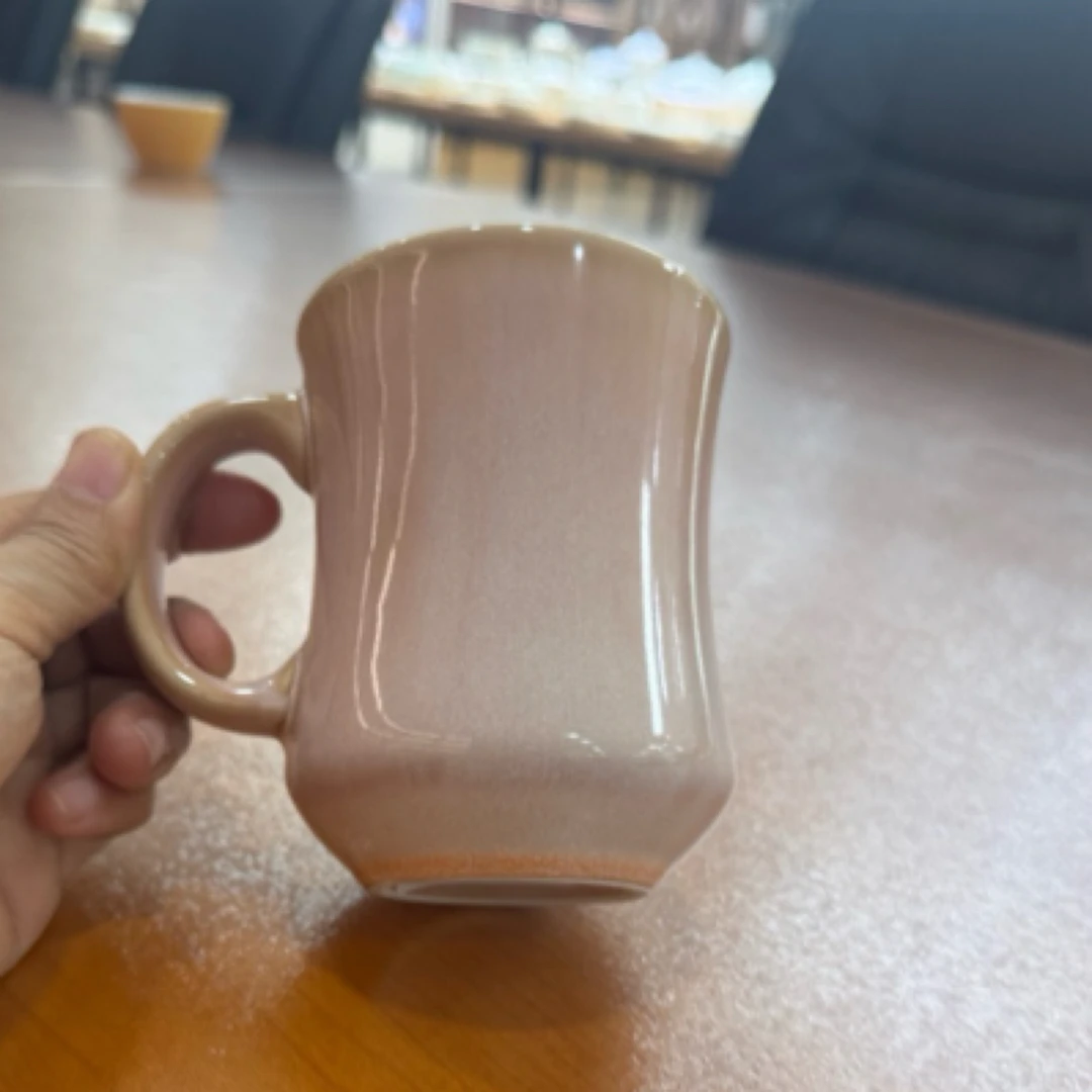 手工淡粉色陶瓷杯，独特弧形杯身，握感舒适，尽显雅致 。