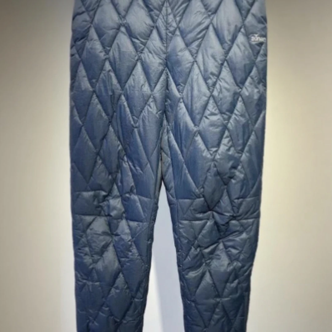 这是Sonam品牌的蓝色羽绒裤局部，裤脚处有松紧收口，侧边有拉链。