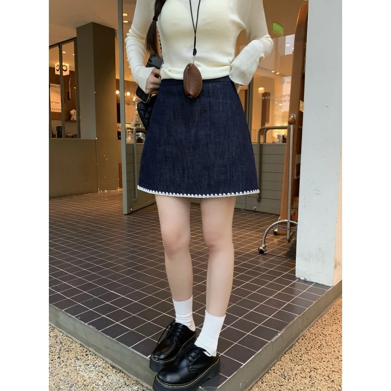 乌77设计感黑色贝壳绣包臀短裙女早秋新款气质通勤百搭a字半身裙