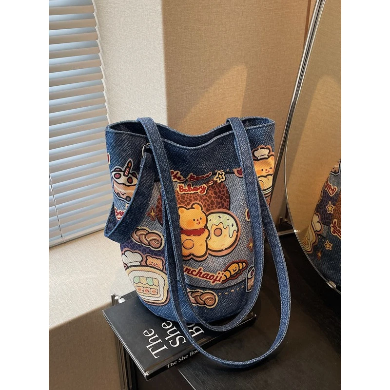 简约质感文艺水桶包包女2025新款可爱卡通布包休闲个性单肩斜挎包