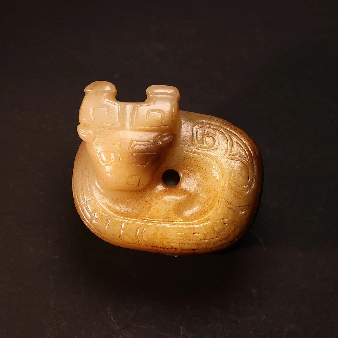 周式龙，和田玉质油润老熟，砣工痕迹明显，局部褐黑特征，有孔可佩戴