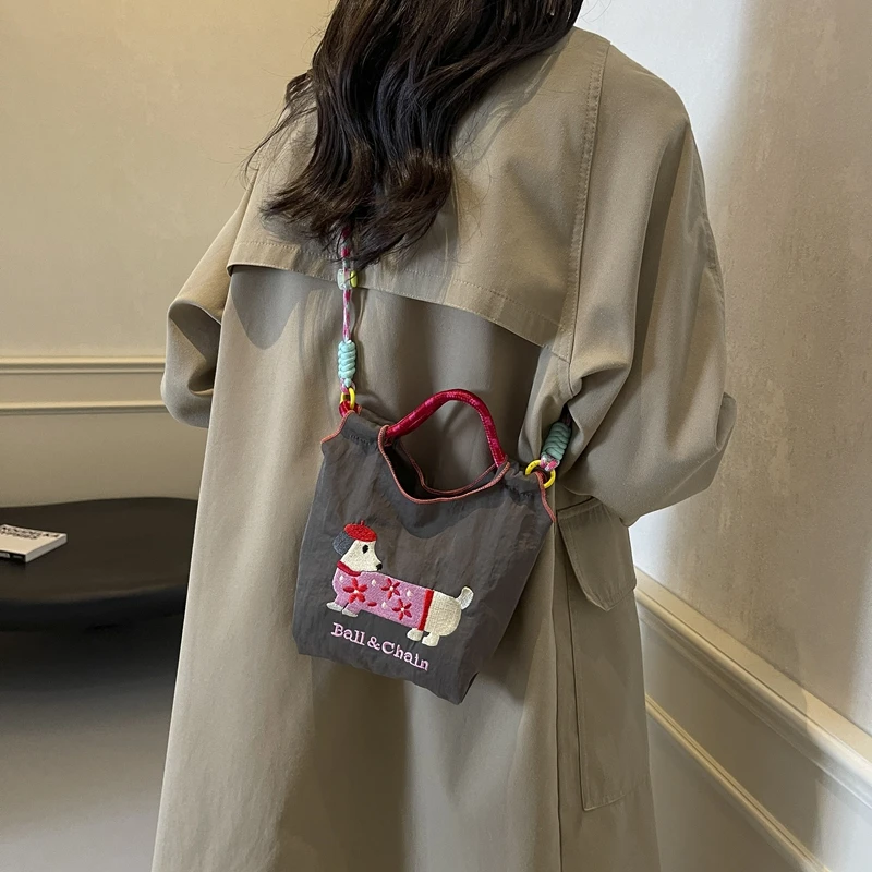 日系刺绣可爱腊肠狗水桶包包女2025新款手机包百搭通勤单肩斜挎包
