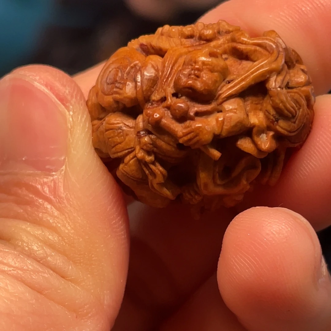 桃核童子戏狮核雕作品