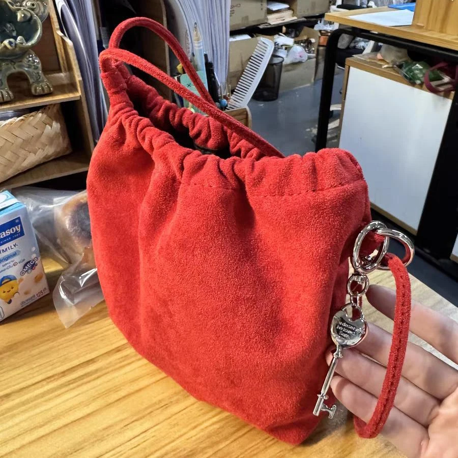 复古红色绒面水桶包女2024新款韩系小众钥匙扣抽绳束口单肩斜挎包
