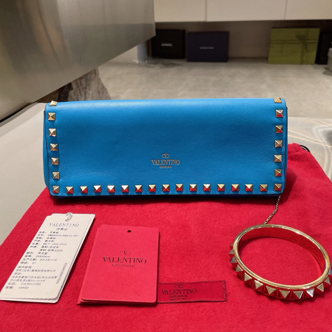 95新 Valentino/华伦天奴 蓝色全皮款手拿包 经典铆钉装饰女士