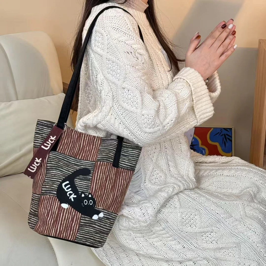 尼睿新款原创复古格纹水桶包可爱猫咪大容量日常通勤单肩包AC