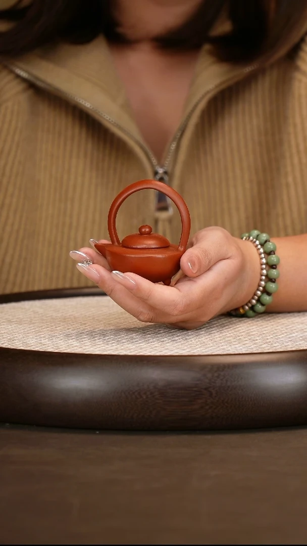 紫砂朱泥三足提梁把把壶