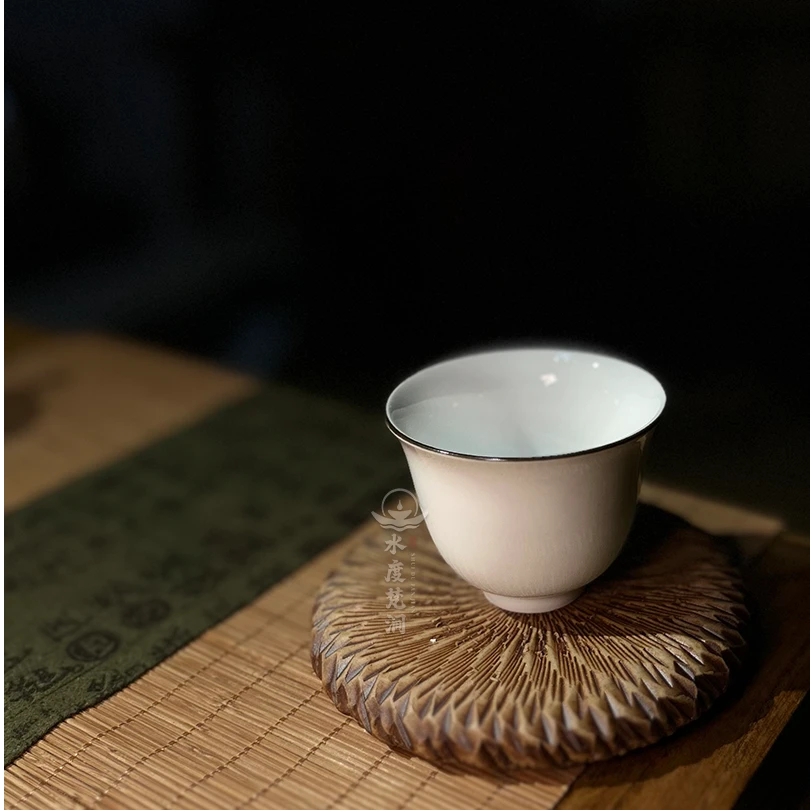 1个纯白色茶杯，杯身搭配黑金色线条装饰，晶莹小巧