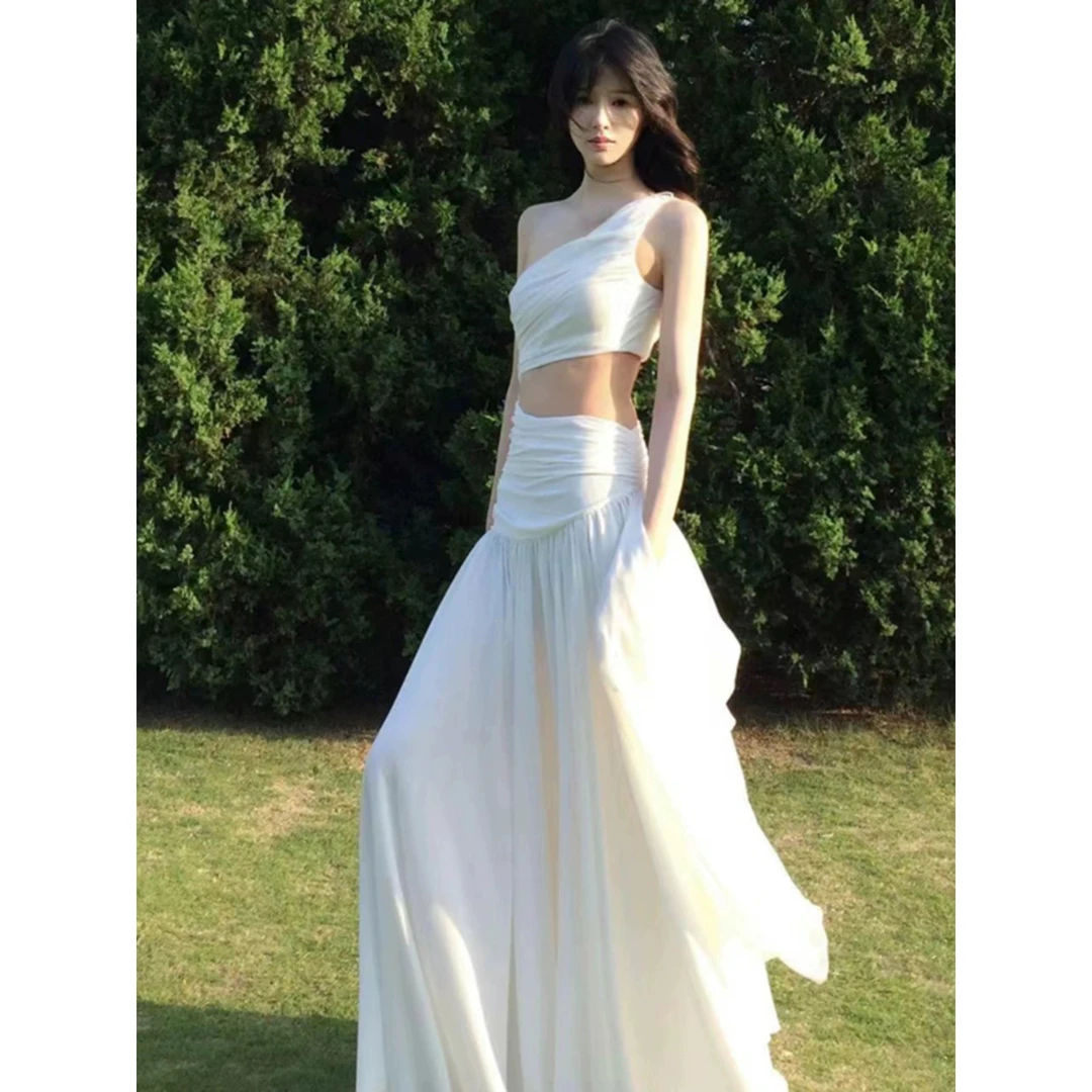 法式超仙白色镂空斜肩连衣裙女夏季高级感气质海边度假露腰长裙子